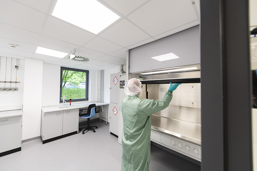 Ein Pharmakant in Schutzkleidung arbeitet im Prozessentwicklungslabor und demonstriert CDMO-Services in einer modernen, sauberen Umgebung.