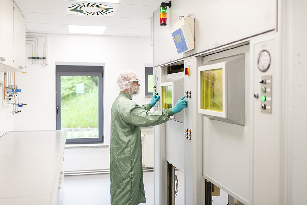 Ein Pharmakant bedient voll abgeschirmte Prozesszelle in einer speziellen Suite für radiopharmazeutische Forschung und Entwicklung und demonstriert hochmoderne CDMO-Services.