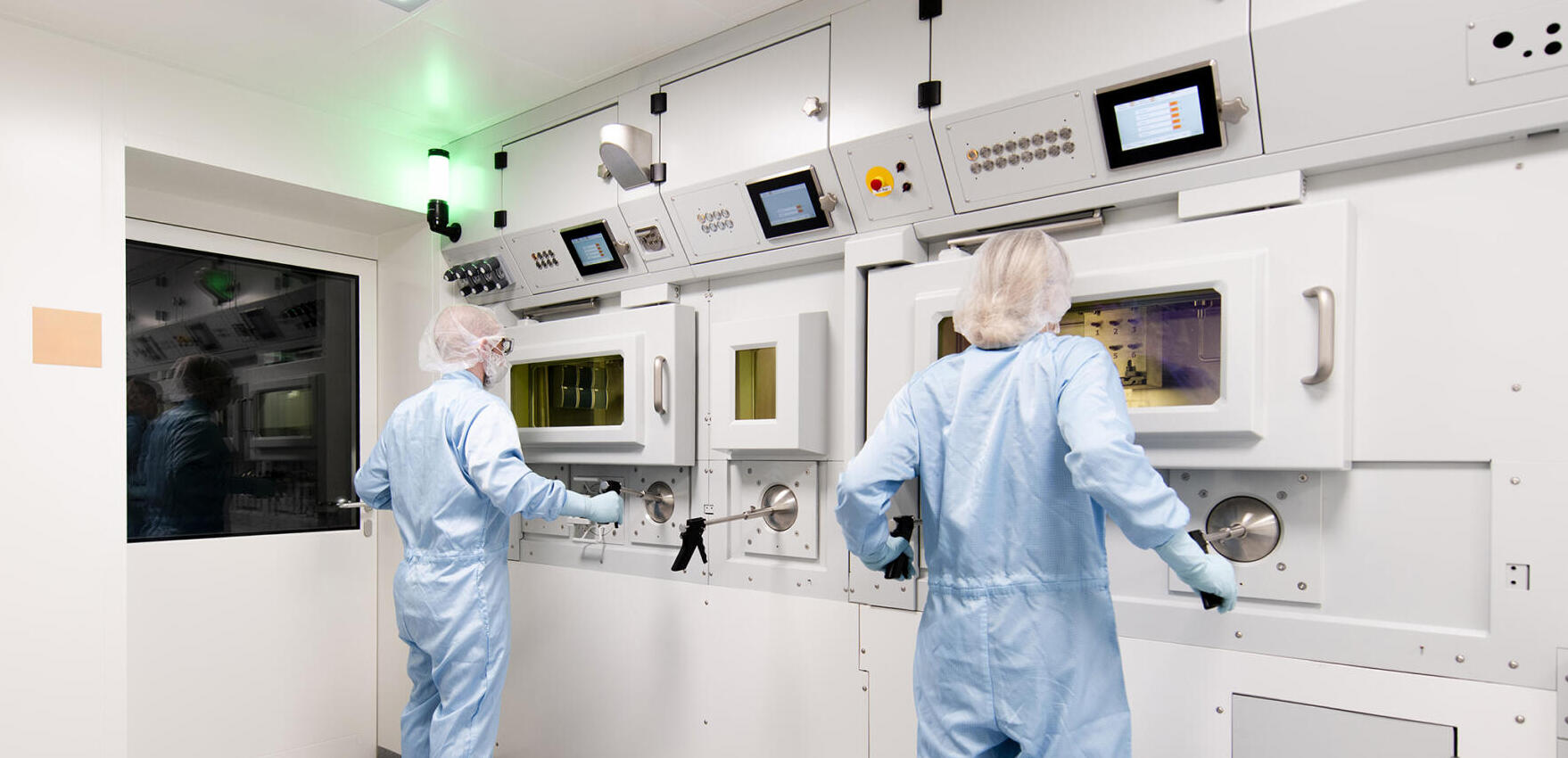 Zwei spezialisierte Experten bedienen eine Prozesszelle für radiopharmazeutische CDMO Services.