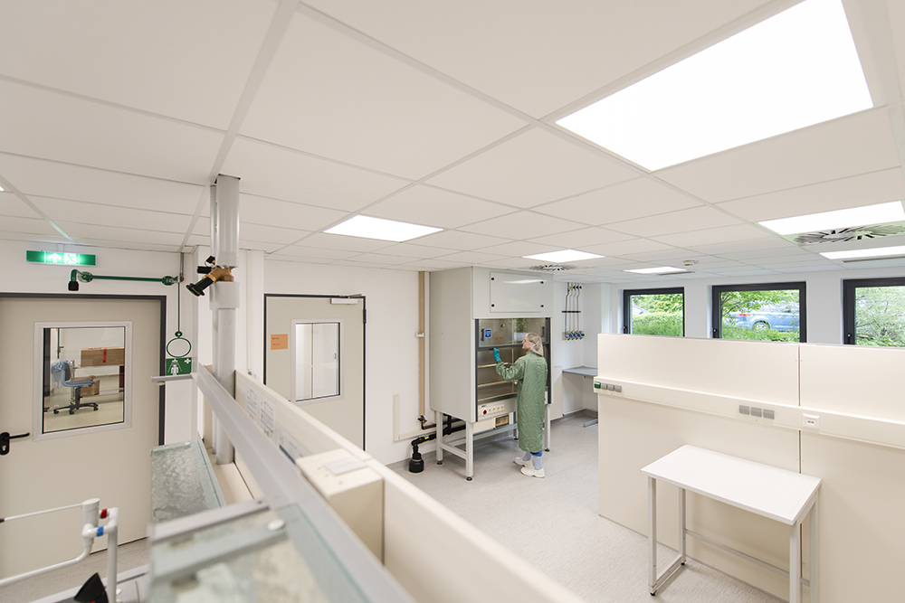 Ein Wissenschaftler arbeitet im geräumigen Reinraum mit Geräten und demonstriert flexible, anpassbare CDMO-Services.